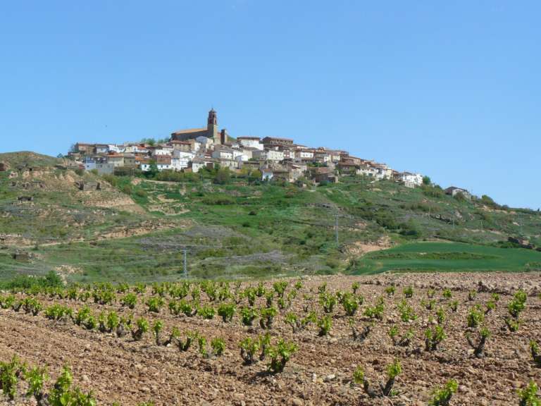 Ein kleines Dorf sitzt auf einem Hügel über einem Feld