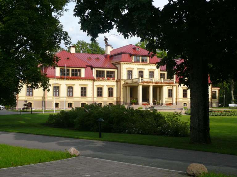 Ein großes Gebäude mit einem roten Dach und vielen Fenstern
