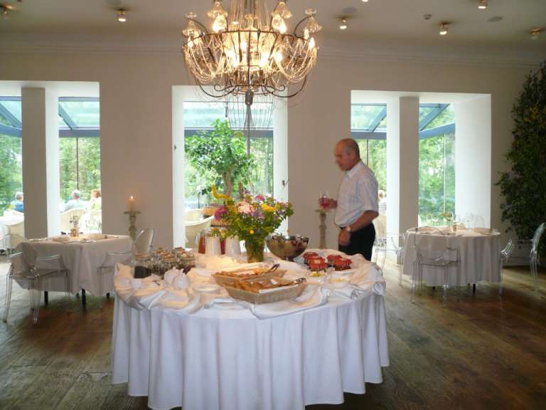 Ein Mann steht vor einem Buffettisch mit einem Kronleuchter darüber