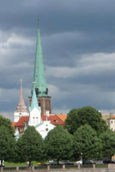 Eine Kirche mit einem grünen Turm und einem Kreuz darauf