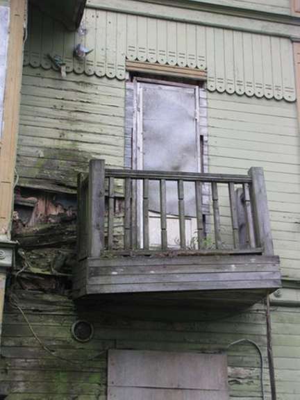 Ein sehr altes Holzgebäude mit einem Balkon und einer Tür .