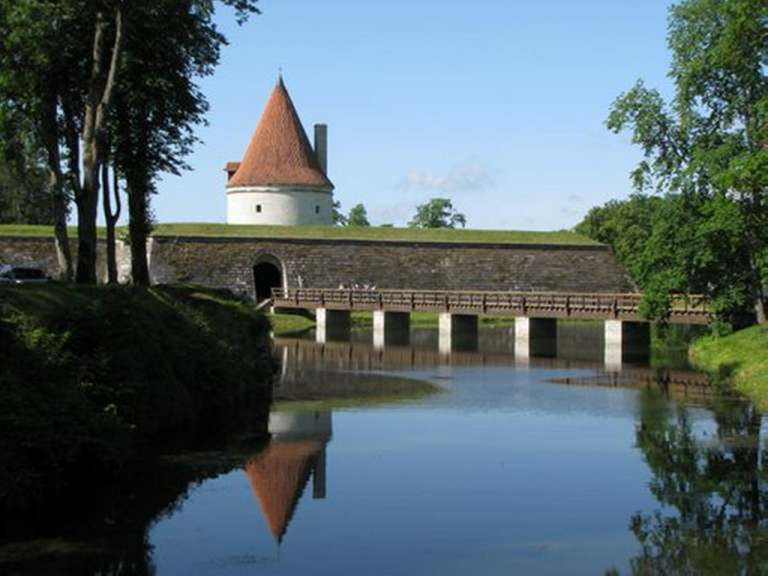 Eine Brücke über einen Fluss mit einem Turm im Hintergrund .