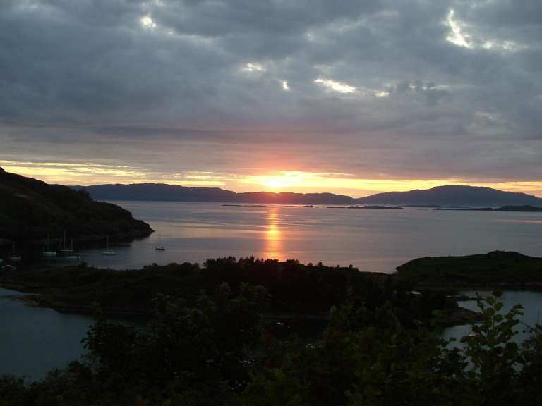 Ein Sonnenuntergang über einem See mit Bergen im Hintergrund