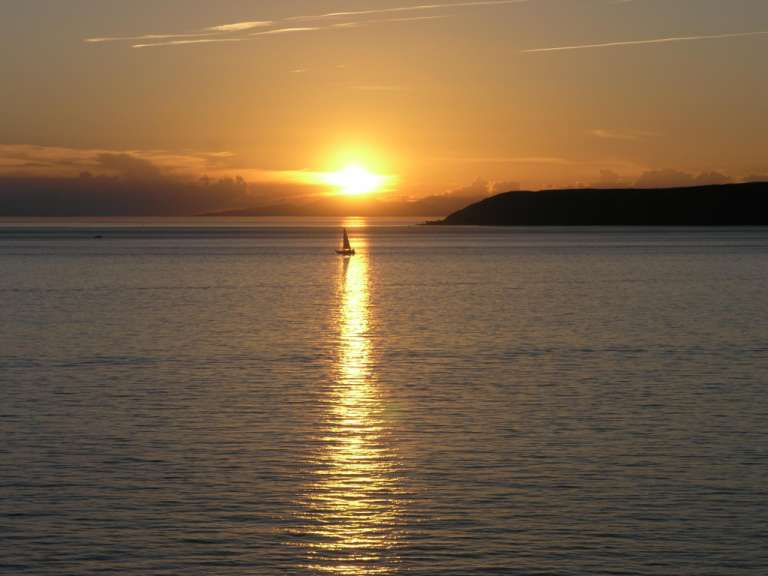 Ein Sonnenuntergang mit einem kleinen Boot im Vordergrund