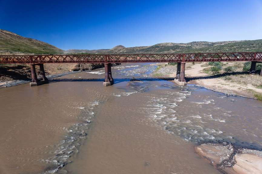Eine Brücke über einen Fluss mit einem blauen Himmel im Hintergrund