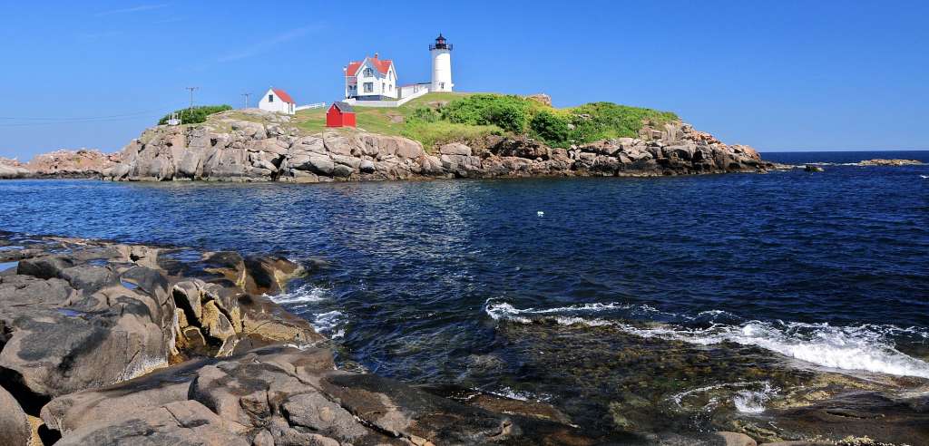 Ein Leuchtturm auf einer kleinen Insel in der Mitte des Ozeans