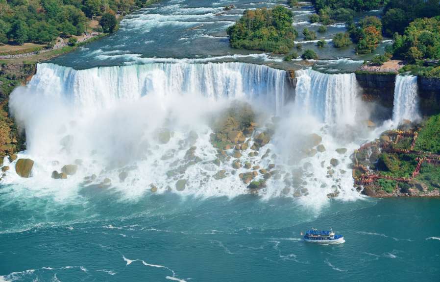 Ein Ausflugsboot fährt durch das ruhige Wasser in der Nähe der tosenden Niagara-Fälle.