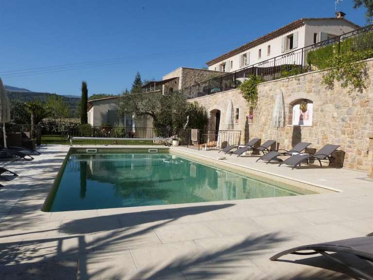 Ein großer Swimmingpool neben einem großen Steingebäude