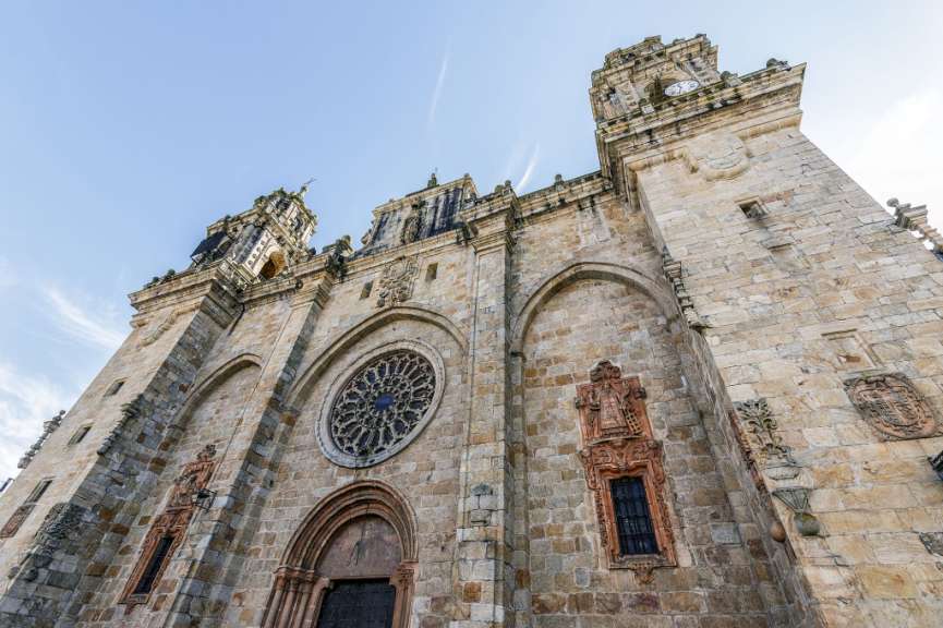 Eine große Steinkirche mit einem großen Fenster und einem Uhrturm