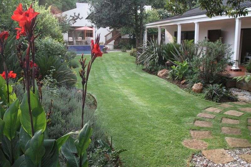 Ein garten mit blumen und einem haus im hintergrund