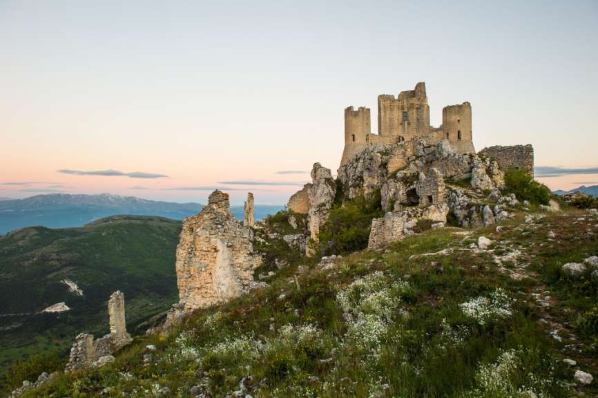 Eine Burgruine steht auf einem felsigen Hügel