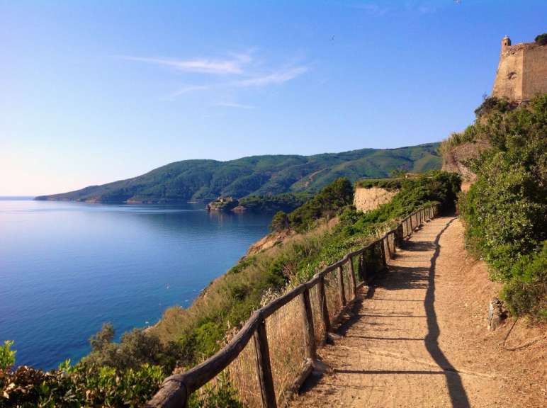 Ein Weg mit einem Holzzaun und einem Blick auf das Meer