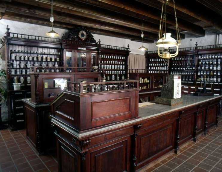 Eine alte Apotheke mit vielen Regalen und einem Tisch