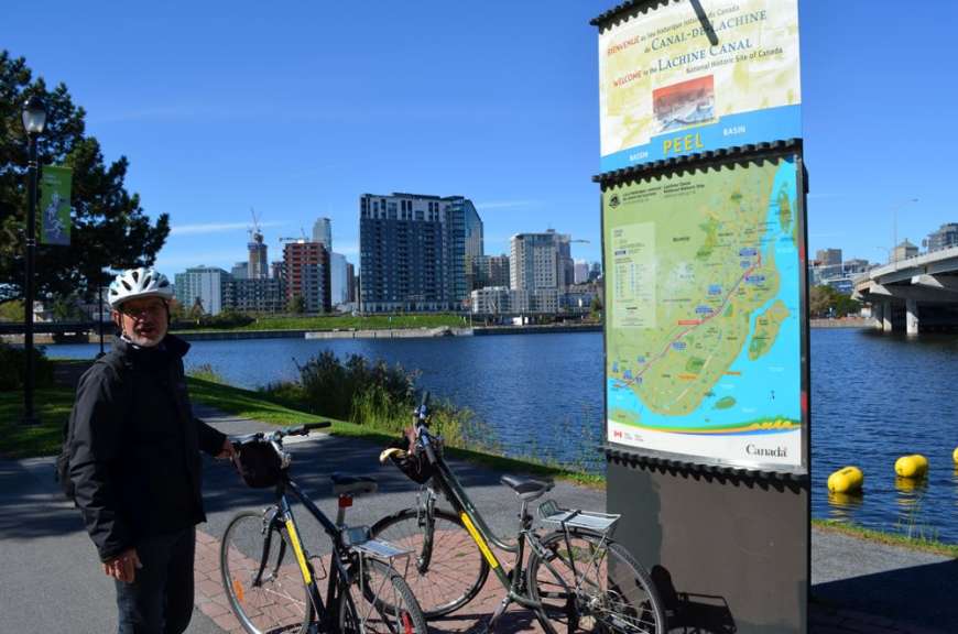 Ein Mann steht neben zwei Fahrrädern neben einem Schild mit der Aufschrift " rvl "