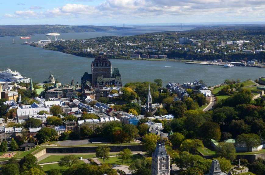 Eine Stadt an einem Fluss mit einem Kreuzfahrtschiff im Hintergrund