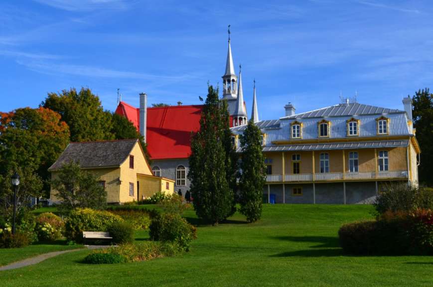 Ein großes Gebäude mit einem roten Dach und einer Kirche dahinter