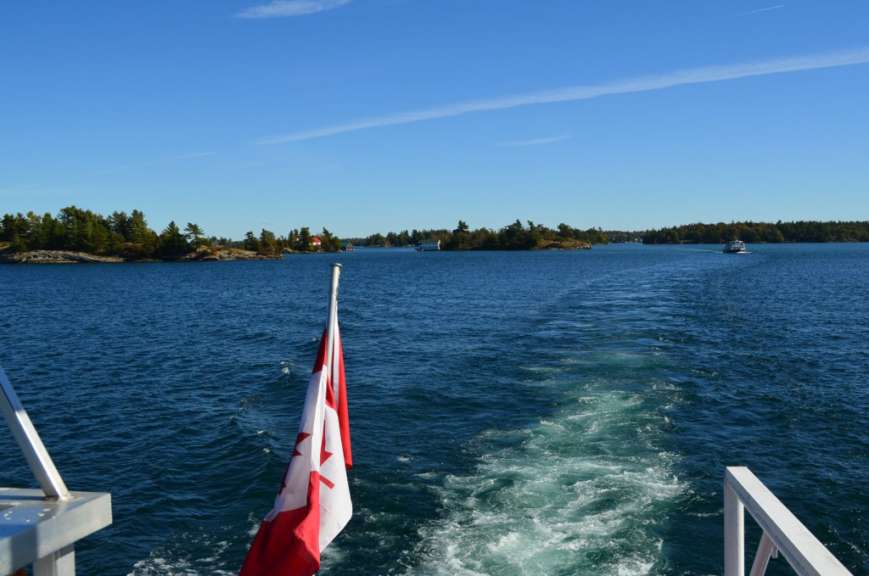 Ein Boot fährt durch einen See mit kleinen Inseln im Hintergrund