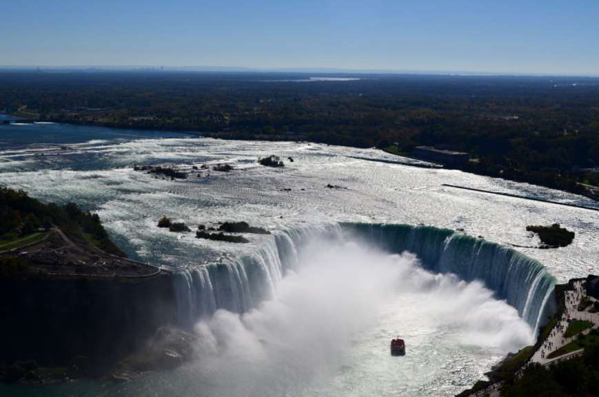 Ein Boot fährt an einem Wasserfall vorbei