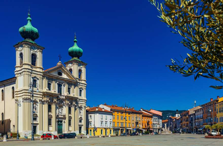 Eine Kirche mit einem grünen Turm und einem Kreuz darauf