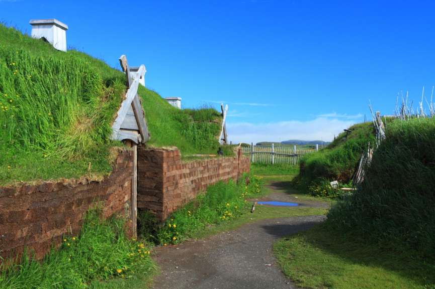 Ein Weg mit einer braunen Wand und einem weißen Gebäude im Hintergrund