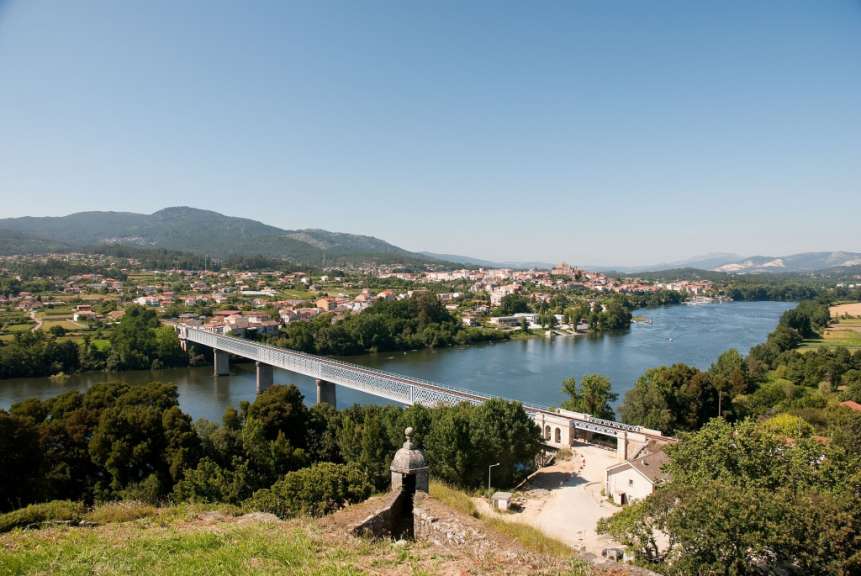 Eine Brücke über einen Fluss mit einem Gebäude im Vordergrund mit der Aufschrift „ universidade “