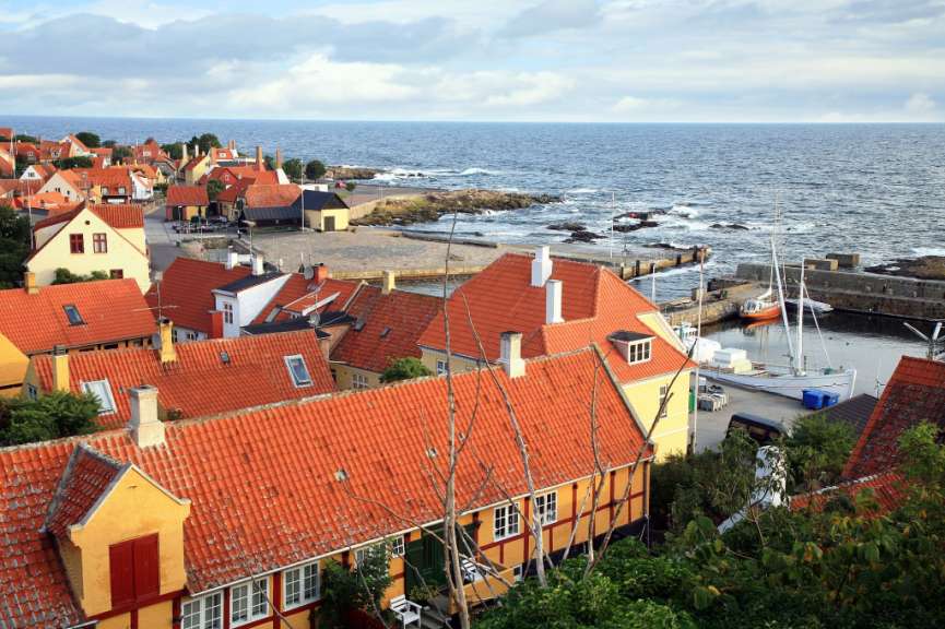 Eine Stadt mit roten Dächern und einem Boot im Hafen