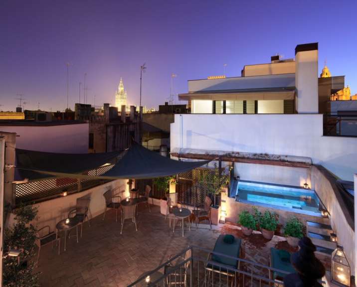 Eine Terrasse mit Tisch und Stühlen und einem Pool