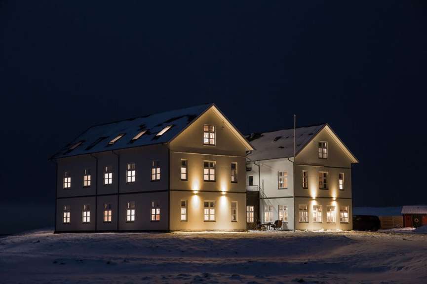 Ein großes weißes Gebäude mit vielen Fenstern in einem schneebedeckten Feld