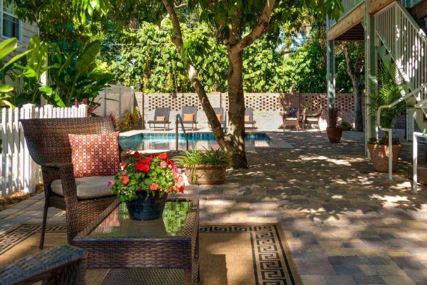 Ein Wohnzimmer mit einem Tisch und Stühlen neben einem Pool