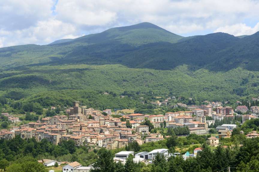 Ein kleines Dorf liegt inmitten einer grünen Bergkette