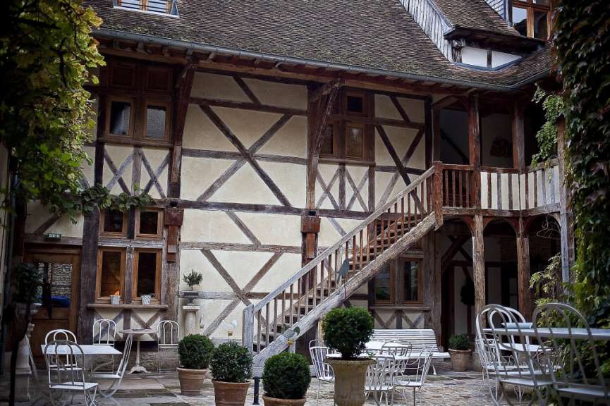 Ein Gebäude mit einer Treppe und einem Tisch und Stühlen davor