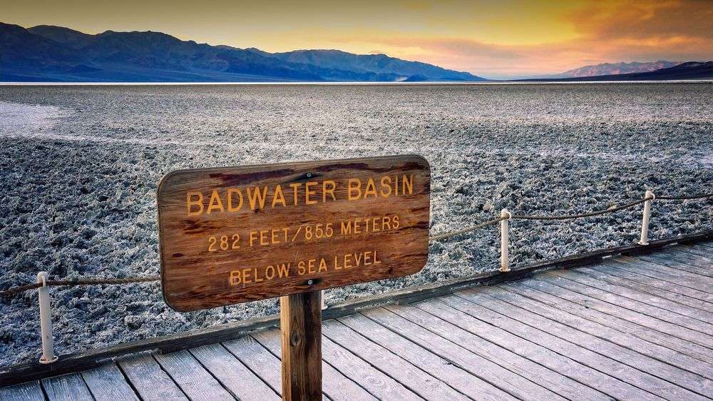 Ein Holzschild auf einem Holzsteg zeigt das Badwater-Basis-Niveau