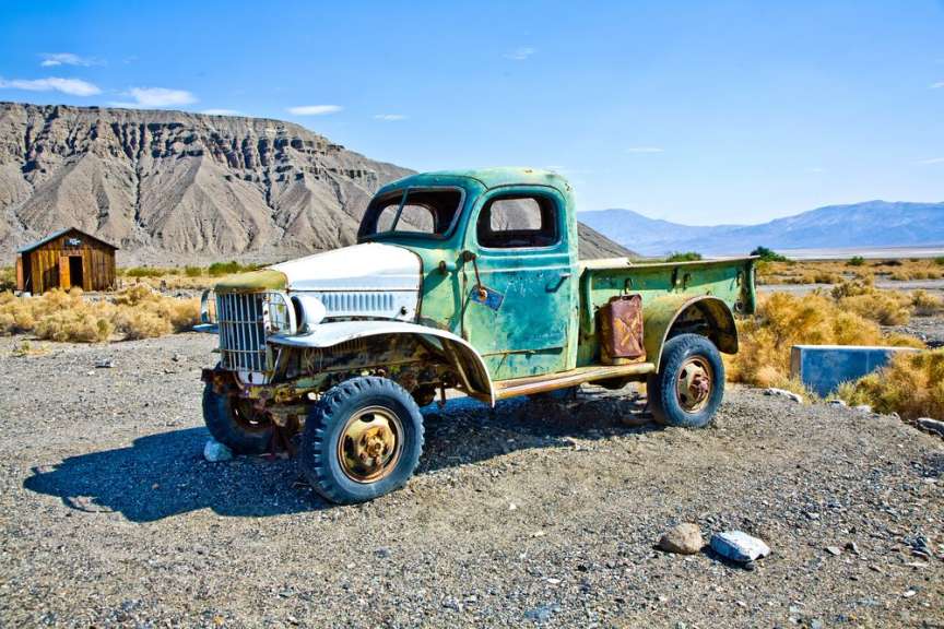 Ein grün-weißer Pickup-Truck steht auf einem Feld