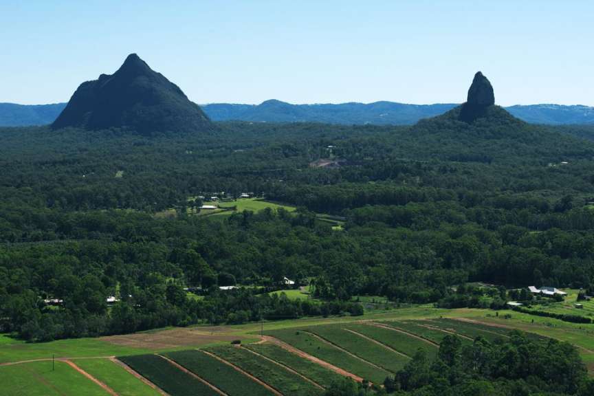Eine landschaft mit einem berg im hintergrund und einem feld im vordergrund