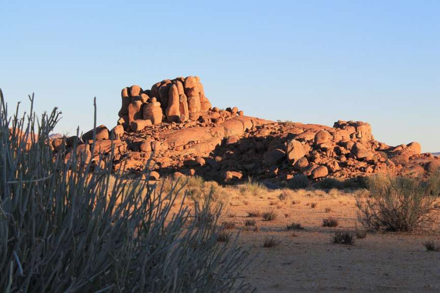 Ein felsiger Hügel in der Wüste mit einem blauen Himmel im Hintergrund