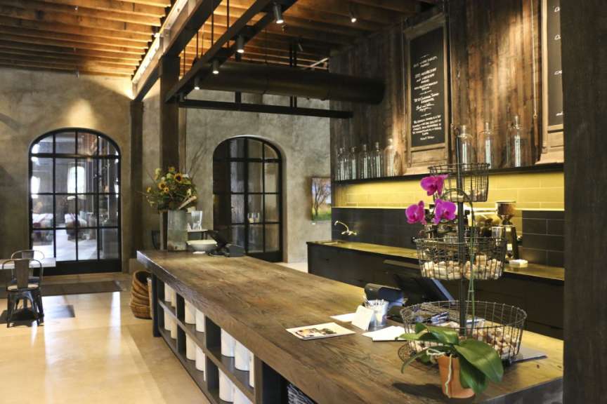 Eine Küche mit einem großen Holztisch und einer schwarzen Tafel mit einem Menü darauf