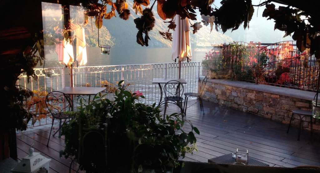 Ein Balkon mit Blick auf einen See und Berge im Abendlicht.
