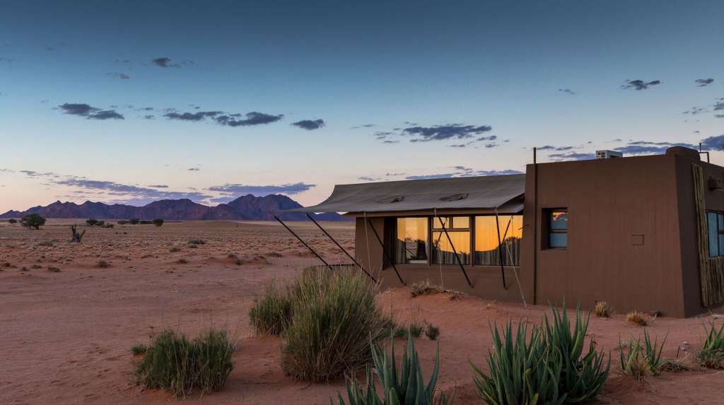 Ein Haus in der Wüste mit einem Zelt darauf