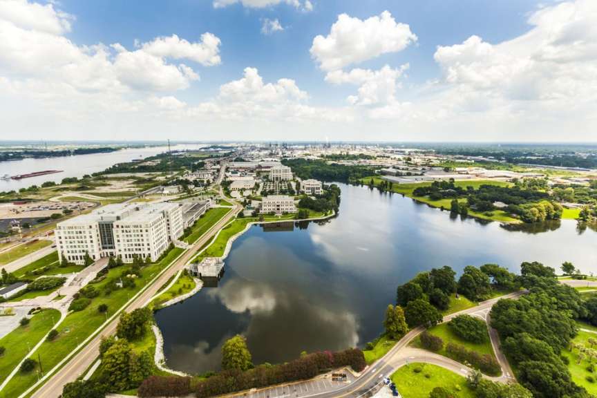 Ein großer See umgeben von Gebäuden und Bäumen