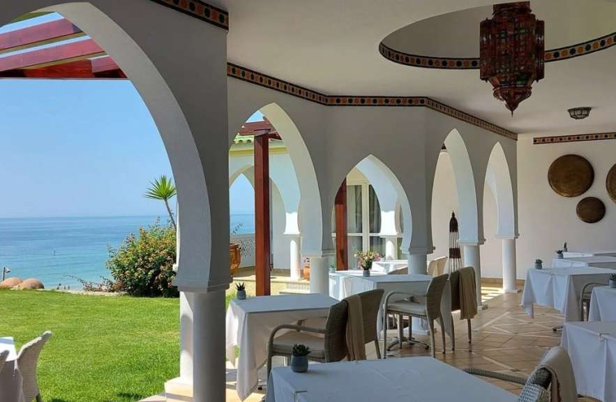 Tische und Stühle in einem Restaurant mit Blick auf den Ozean