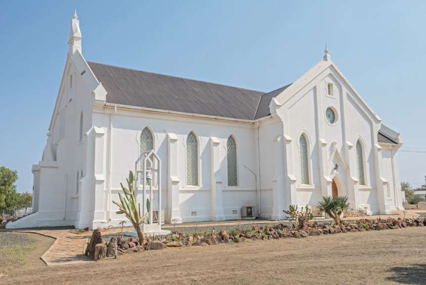 Eine weiße Kirche mit einem schwarzen Dach und vielen Fenstern