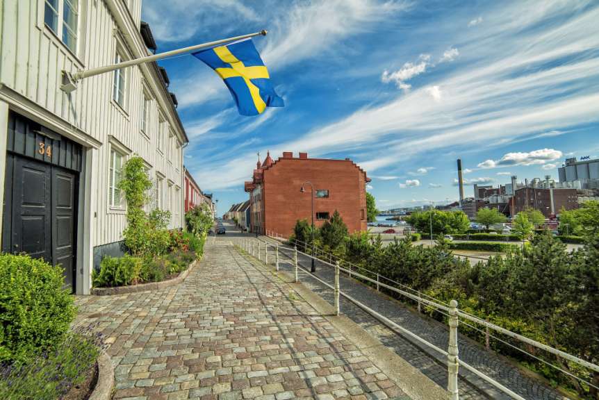 Eine schwedische Flagge weht vor einem Haus mit der Hausnummer 34