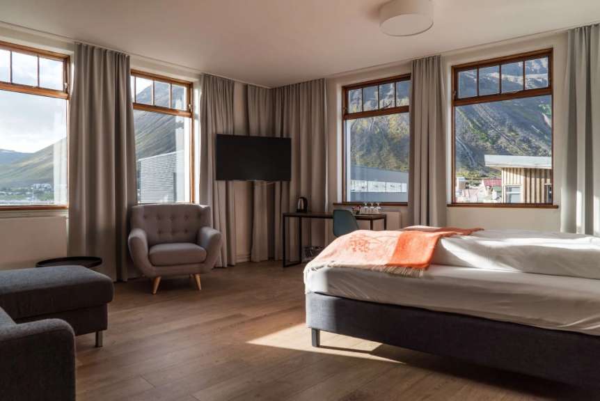 Ein Hotelzimmer mit einem Bett, einem Stuhl und einem Fernseher
