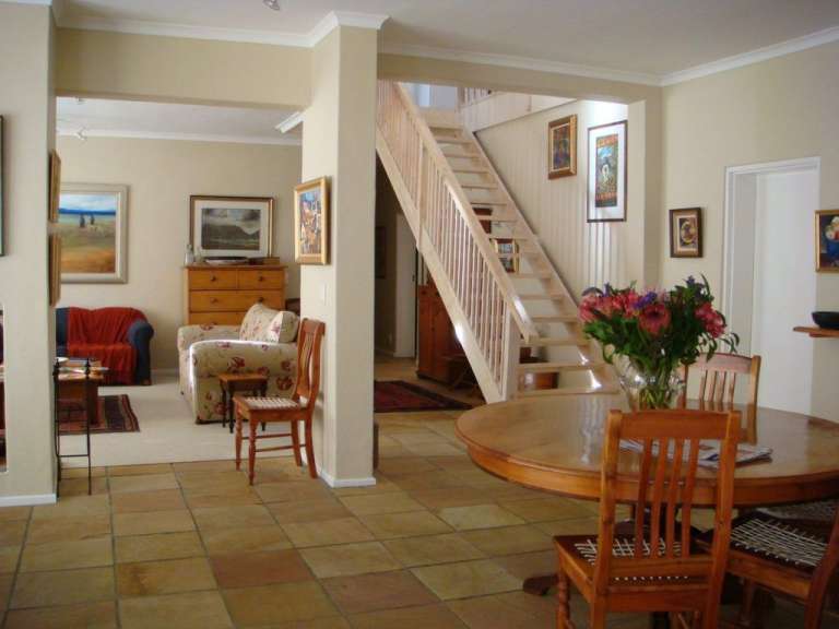 Ein Wohnzimmer mit einem Tisch und Stühlen und einer Treppe