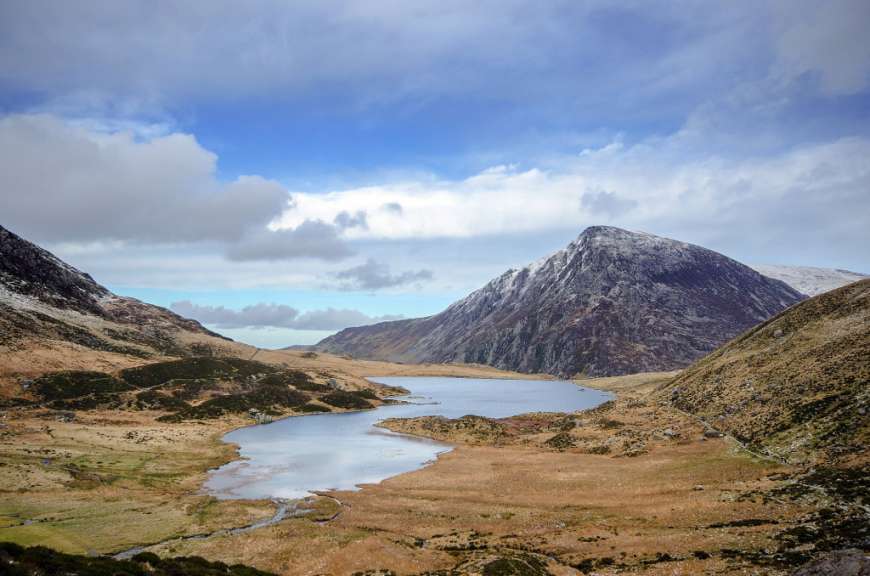 Ein See inmitten einer Bergkette mit einem schneebedeckten Berg im Hintergrund