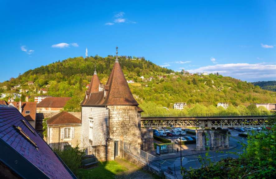 Ein Gebäude mit einem Turm auf einem Hügel im Hintergrund
