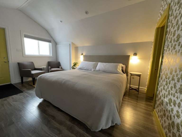 Ein Schlafzimmer mit einem Bett und zwei Stühlen
