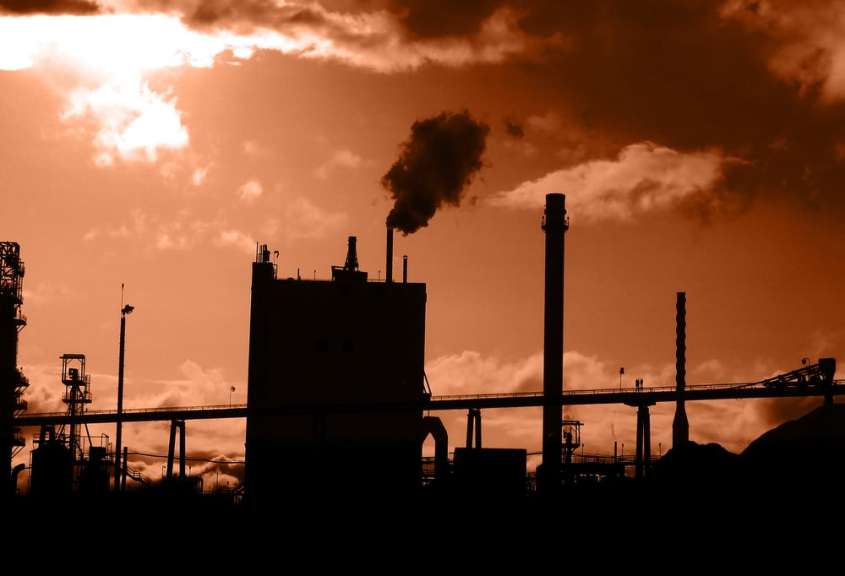 Eine Silhouette einer Fabrik mit Rauch aus den Schornsteinen