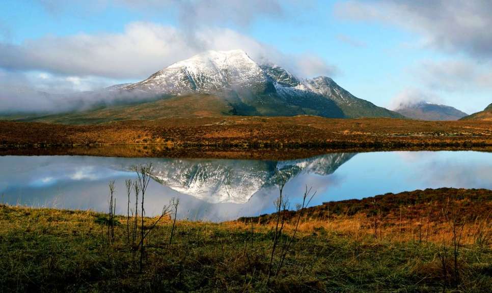 Ein schneebedeckter Berg spiegelt sich in einem See