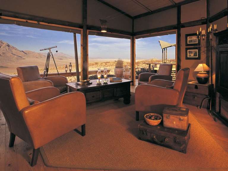 Ein Wohnzimmer mit vielen Stühlen und einem Tisch